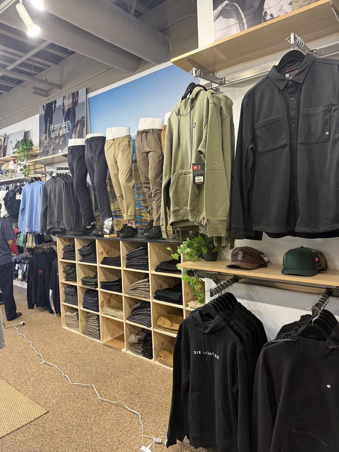 686 pants, shirts, and caps on a wall