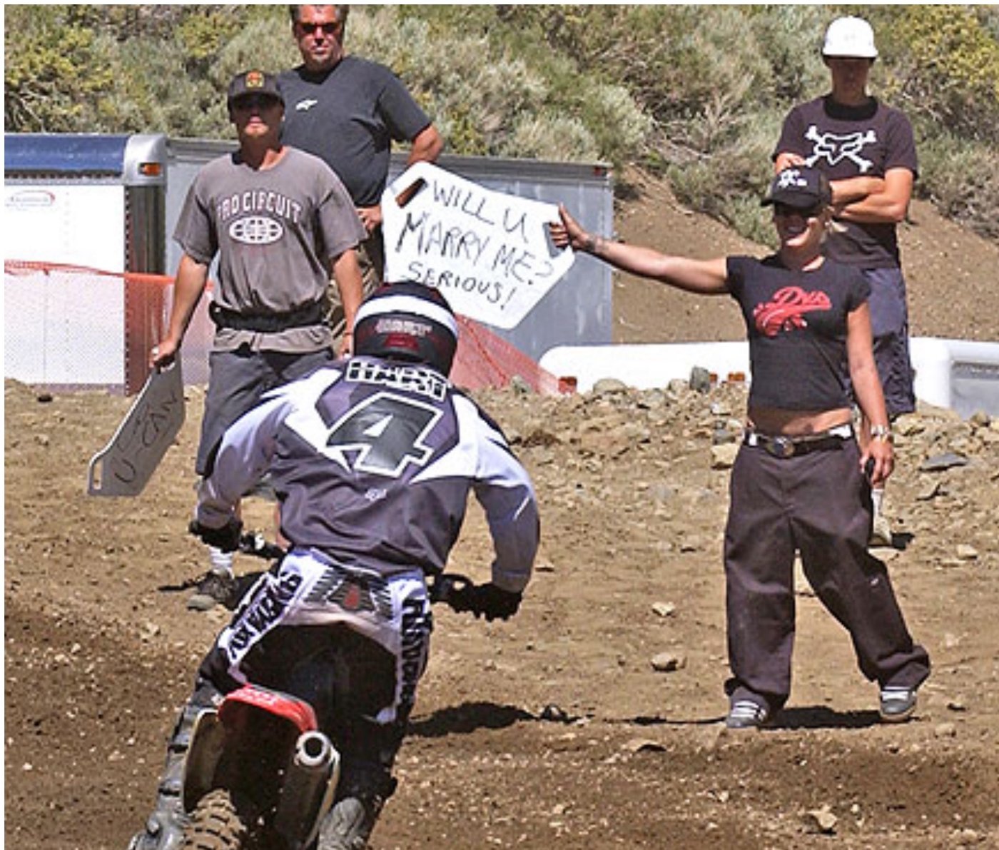 Pink in a DVS tee holding a sign asking Carey Hart to marry her