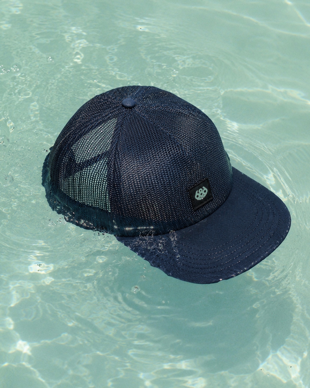 Mesh trucker cap floating in a pool